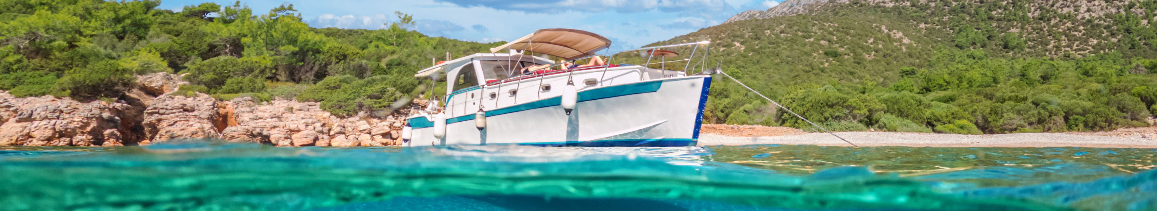 Marineyacht im Meer und halbe Unterwasseransicht des Meeresbodens in Bodrum, Türkei.