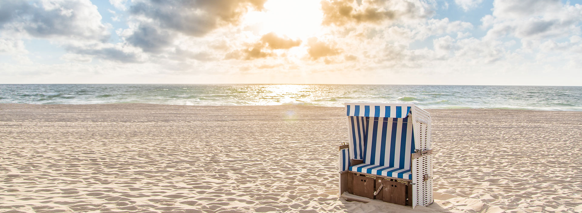 Einzelner Strandkorb bei Sonnenuntergang an der Nordsee