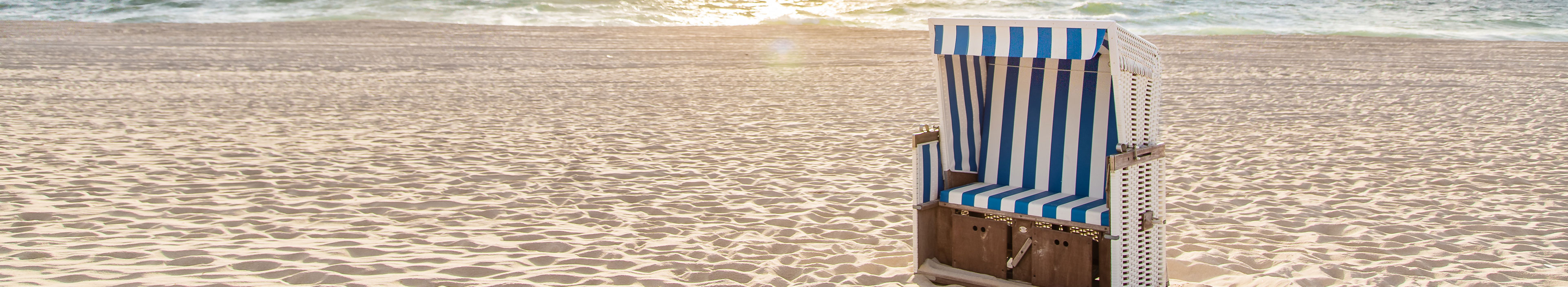 Einzelner Strandkorb bei Sonnenuntergang an der Nordsee