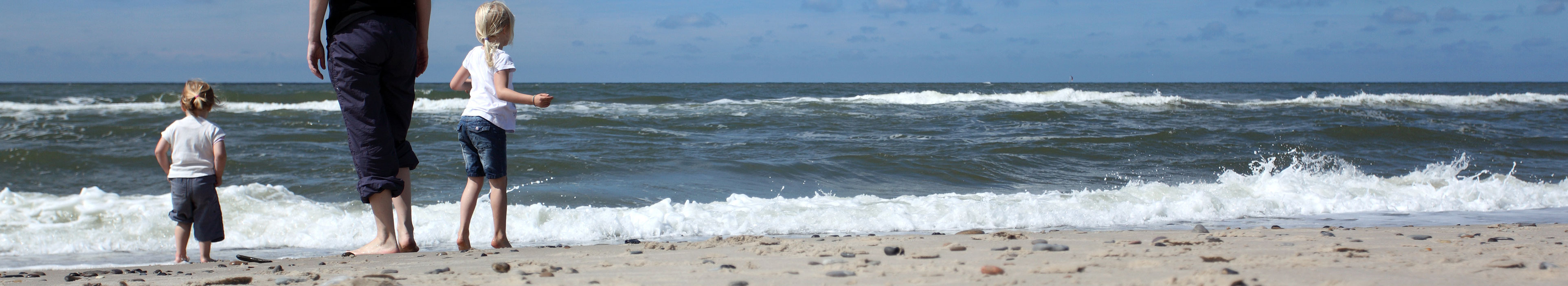 Eine Mutter mit ihren zwei Kindern am Strand in Dänemark.
