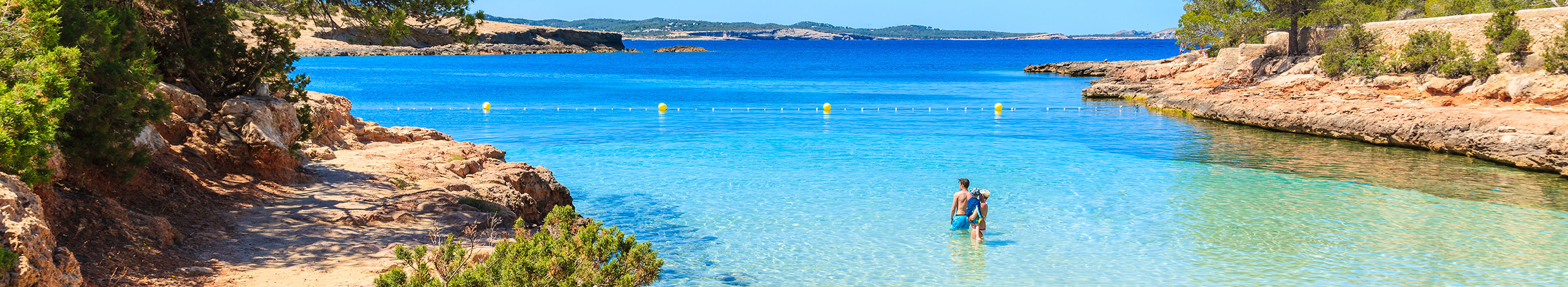 Familie schwimmt im Meer an einer Bucht auf Ibiza