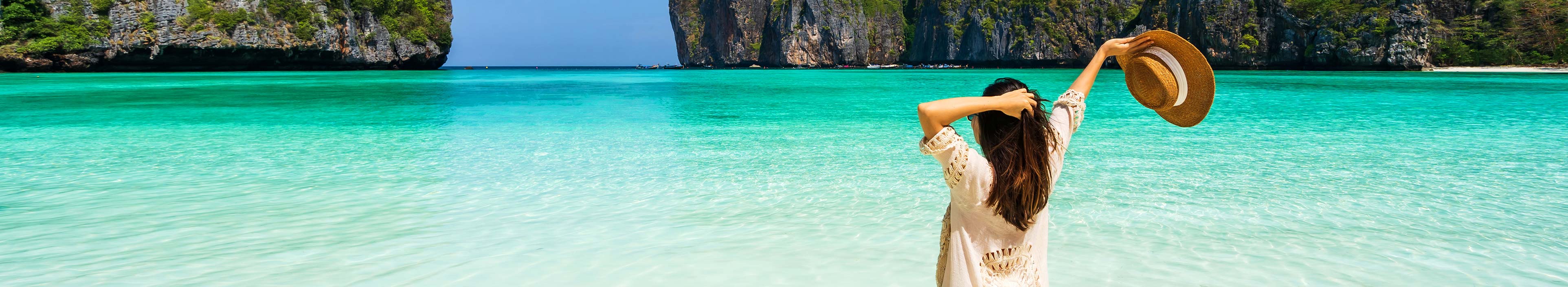 Junge Frau, die sich während einer Pauschalreise am wunderschönen tropischen weißen Sandstrand in der Maya-Bucht in Krabi, Thailand entspannt.