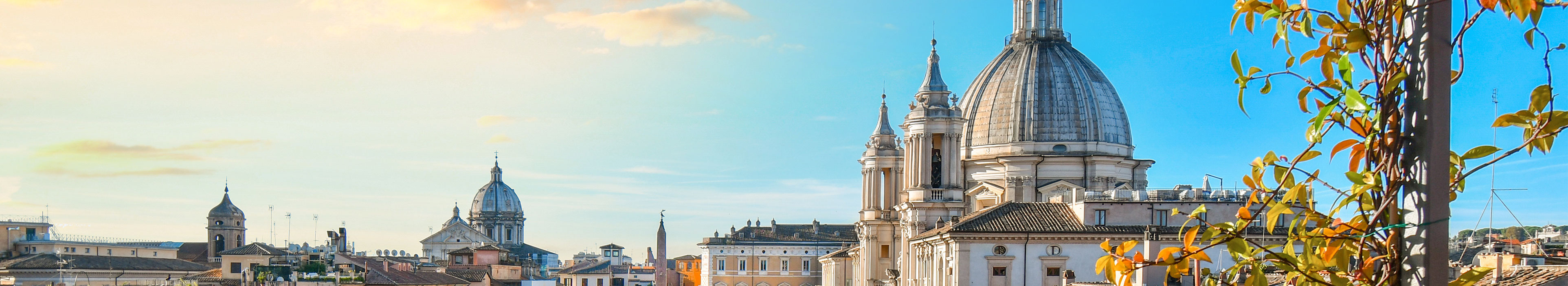 Eine Frau sitzt in einem Hotel in Rom beim Frühstück und blickt auf einen Platz in der Stadt.
