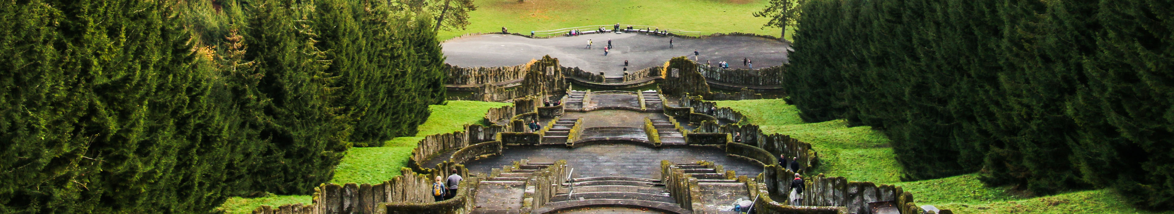 Blick auf Kassel, im Vordergrund Stufen, links und rechts Bäume.